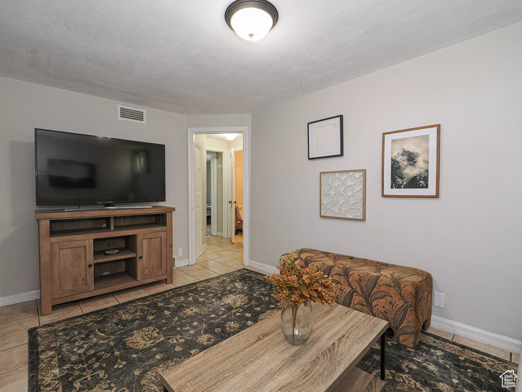Living room featuring light tile patterned floors, visible vents, and baseboards