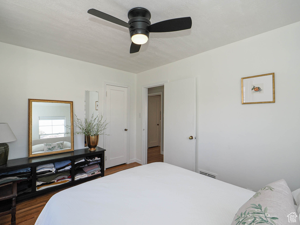 Bedroom featuring dark wood-type flooring, visible vents, and ceiling fan