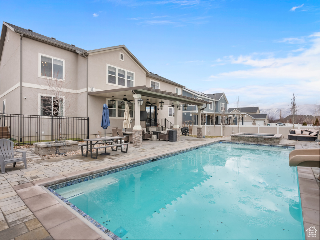 Exterior space featuring a ceiling fan, a water slide, fence, and a patio