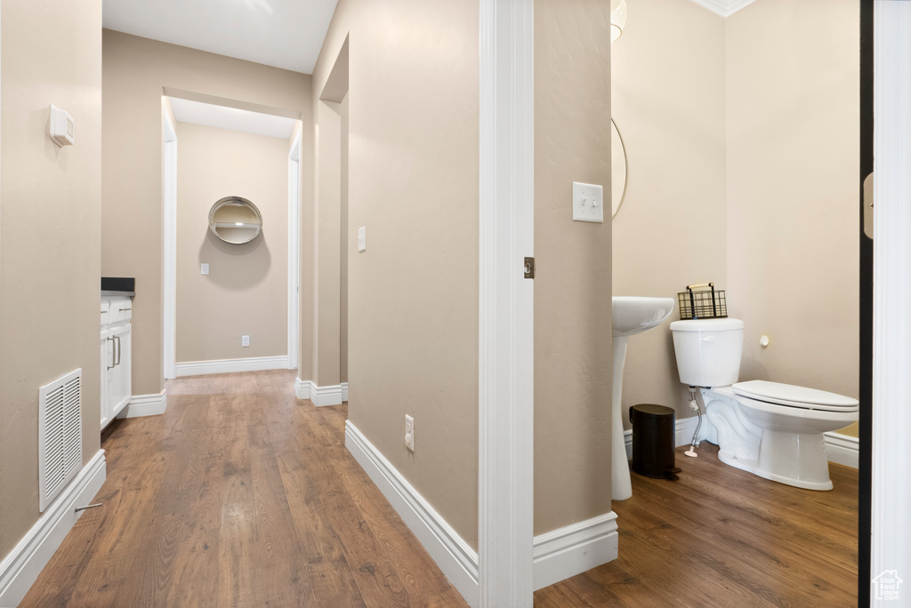 Corridor featuring wood finished floors, visible vents, and baseboards