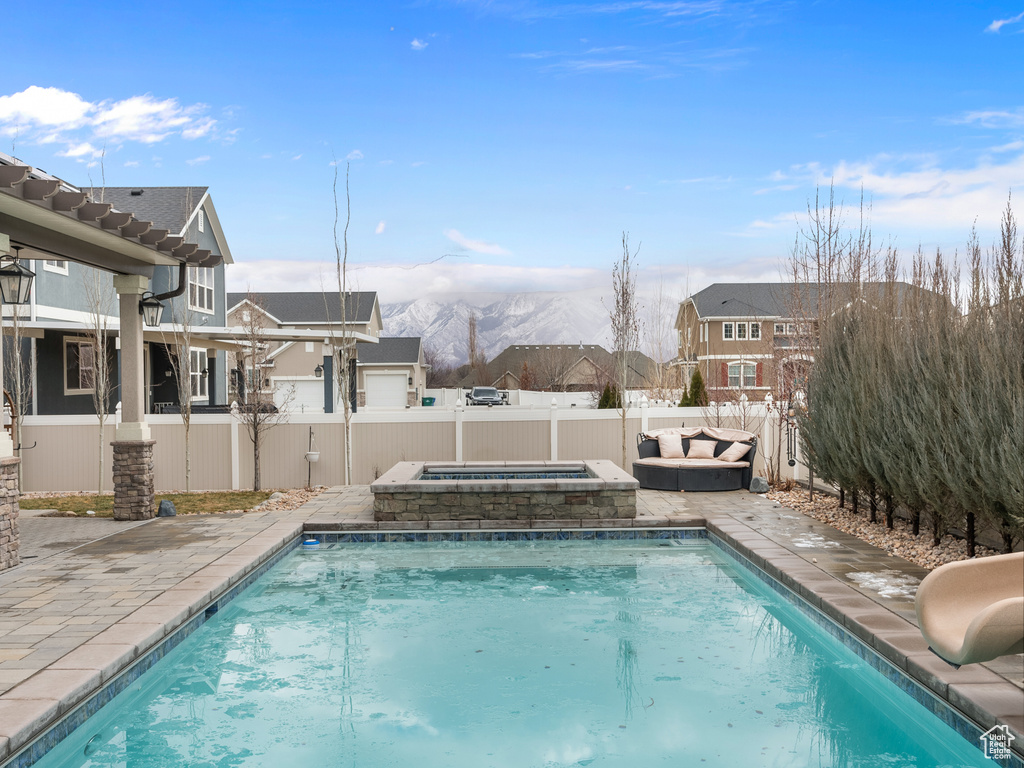 View of swimming pool featuring a fenced in pool, a fenced backyard, an in ground hot tub, a water slide, and a mountain view