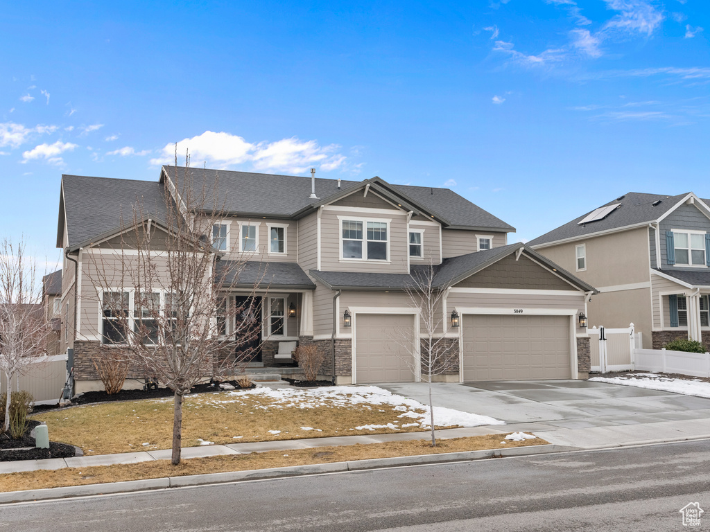 View of front of home with a garage, driveway, roof with shingles, and a residential view