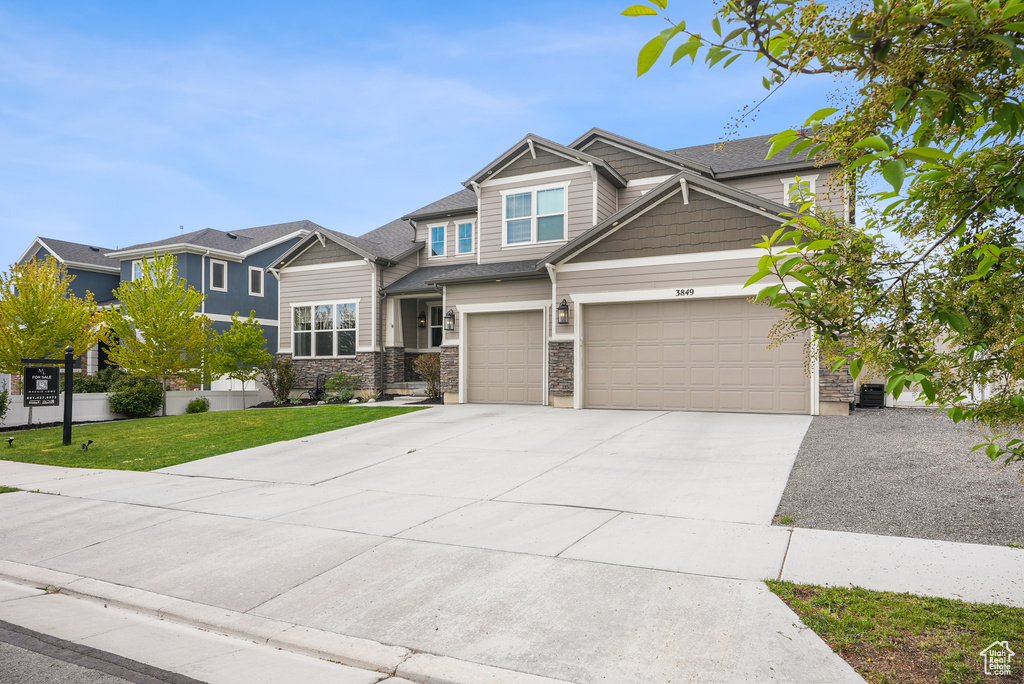 Craftsman house with concrete driveway, a front lawn, and a garage
