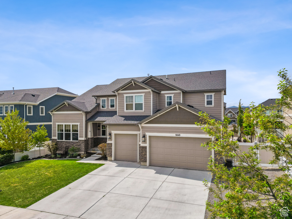 Craftsman house featuring driveway, a garage, and stone siding