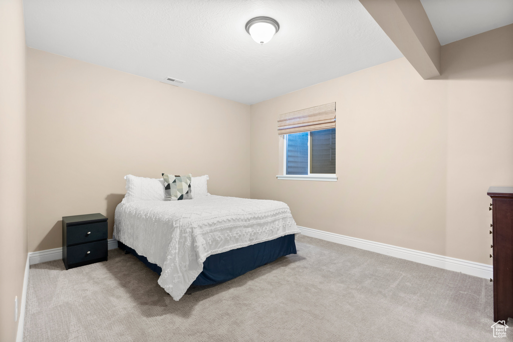 Bedroom featuring baseboards, visible vents, and light colored carpet