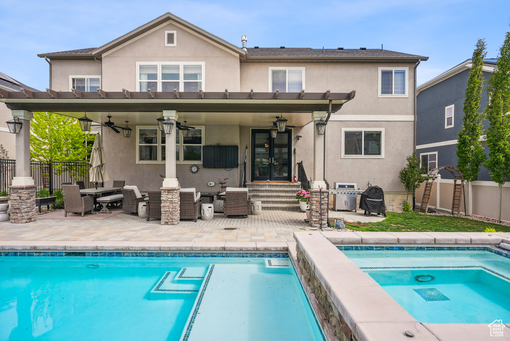 Rear view of property with stucco siding, ceiling fan, and a fenced backyard