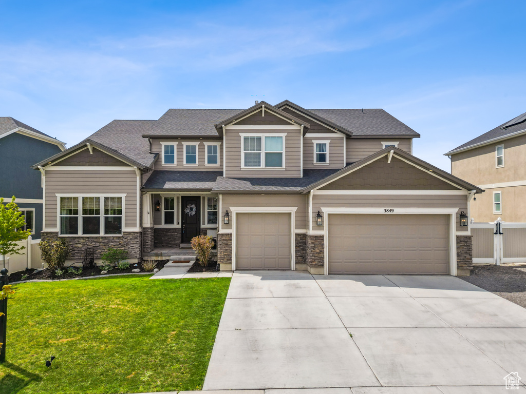 Craftsman inspired home featuring driveway and stone siding