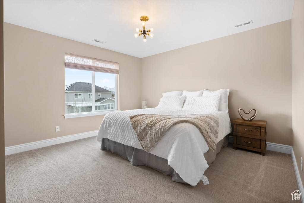 Bedroom featuring baseboards, visible vents, and light colored carpet