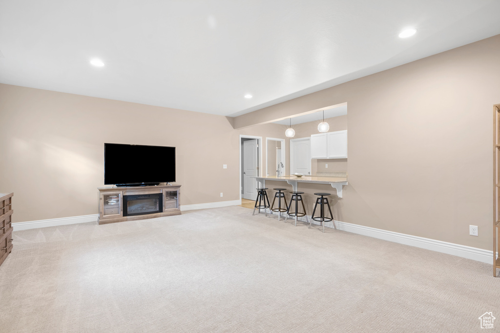 Living area featuring recessed lighting, light carpet, and baseboards