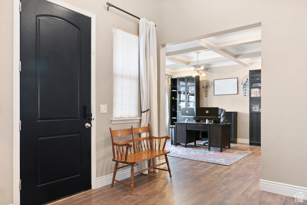 Foyer entrance featuring beamed ceiling, coffered ceiling, wood finished floors, and baseboards