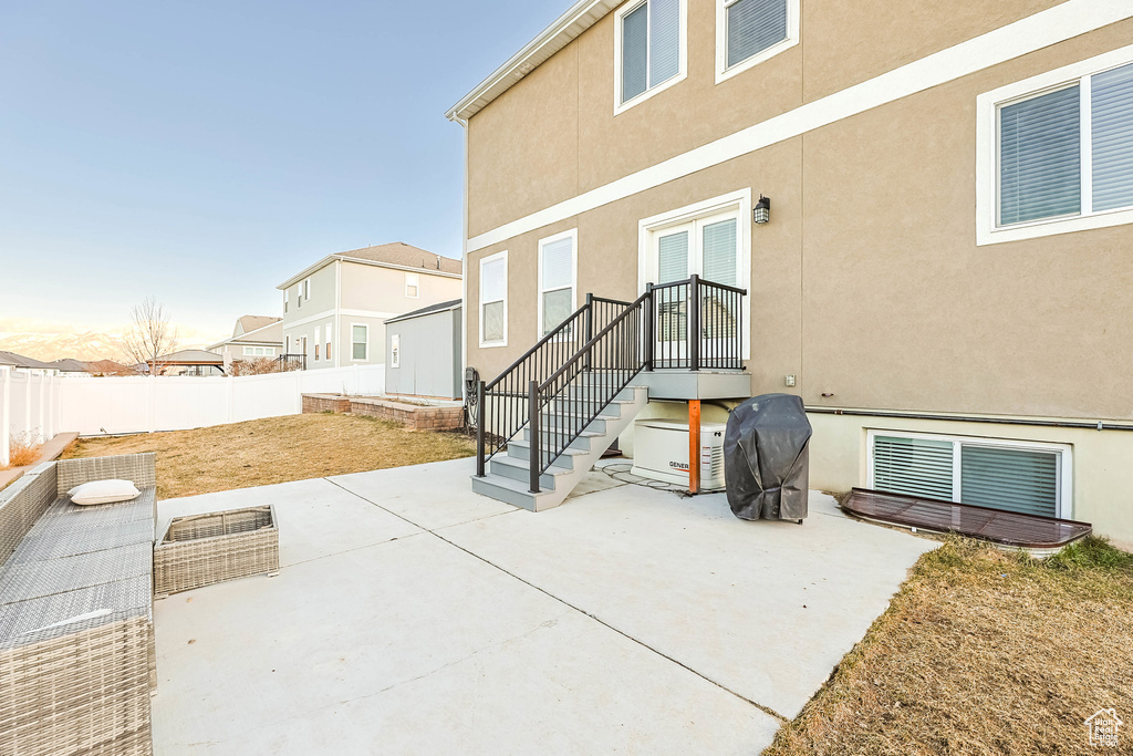 Rear view of property featuring stucco siding, a fenced backyard, and a patio