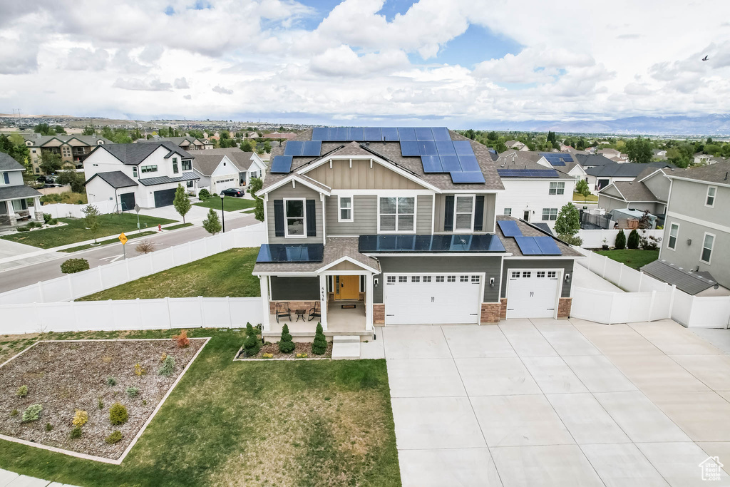 View of front of property with a residential view, board and batten siding, driveway, and solar panels