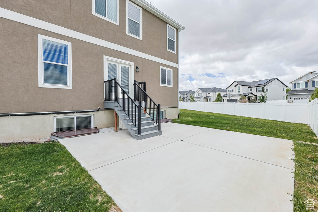 Rear view of property with a residential view, stucco siding, and a patio
