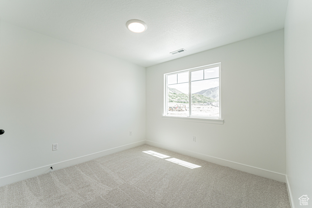 Carpeted empty room featuring baseboards
