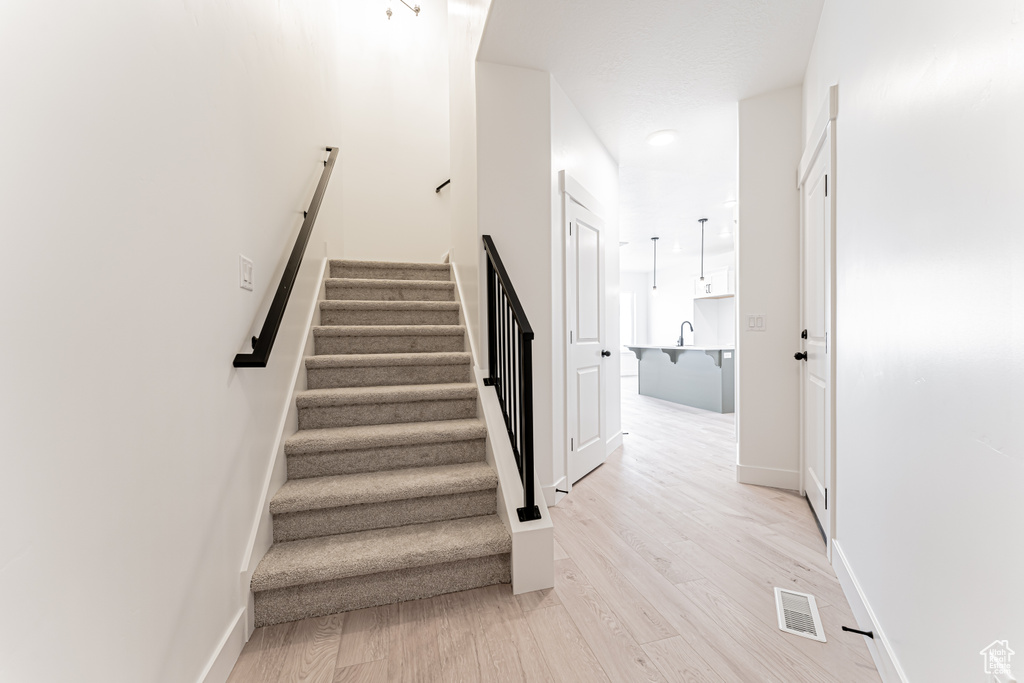 Stairs with wood finished floors and baseboards