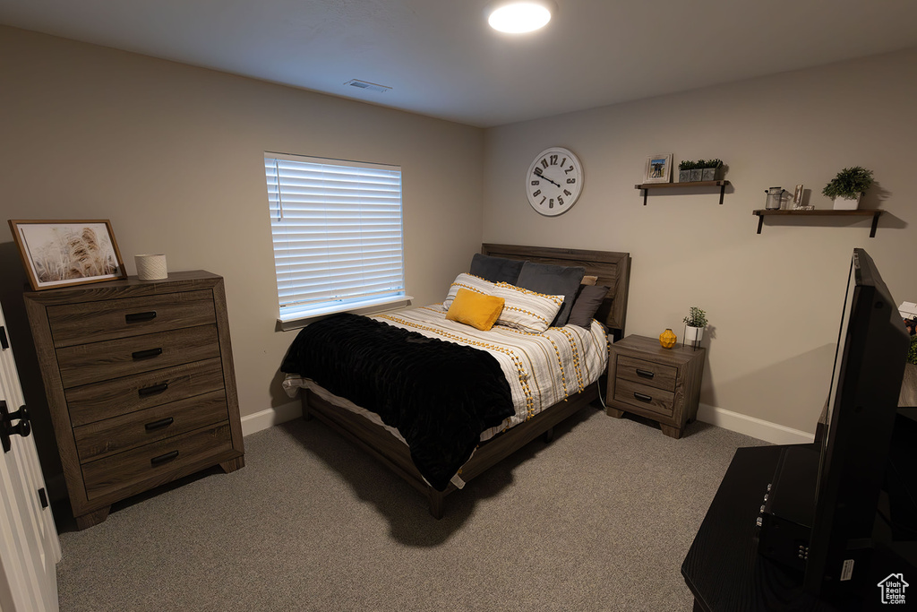Bedroom featuring light carpet, visible vents, and baseboards