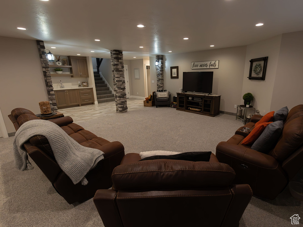 Living room featuring light carpet, decorative columns, bar, stairs, and recessed lighting