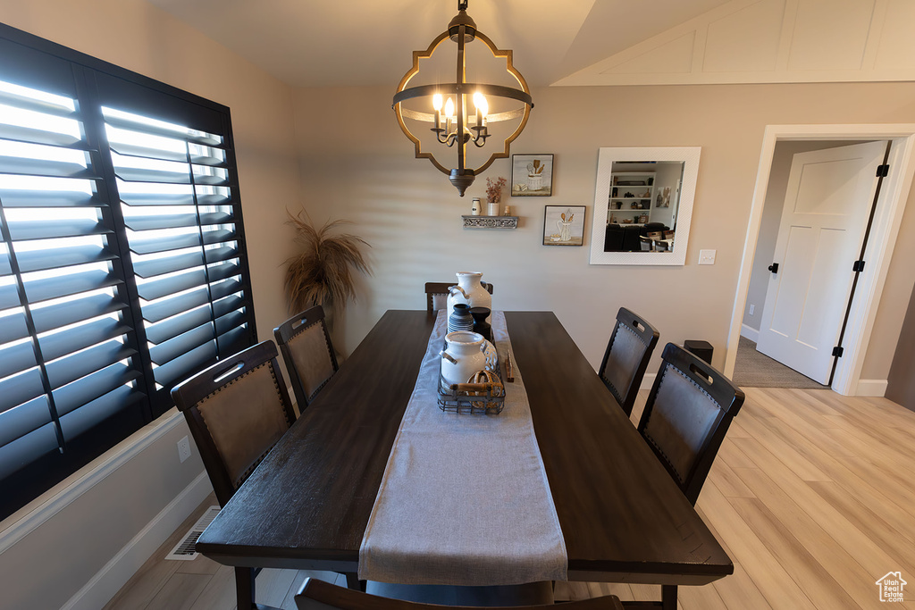 Dining area featuring baseboards, wood finished floors, and a notable chandelier