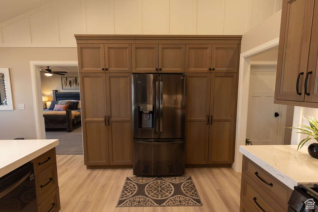 Kitchen featuring stainless steel fridge, light countertops, dishwasher, and light wood-style flooring