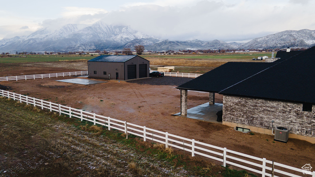 View of yard with an outbuilding, a rural view, and a mountain view