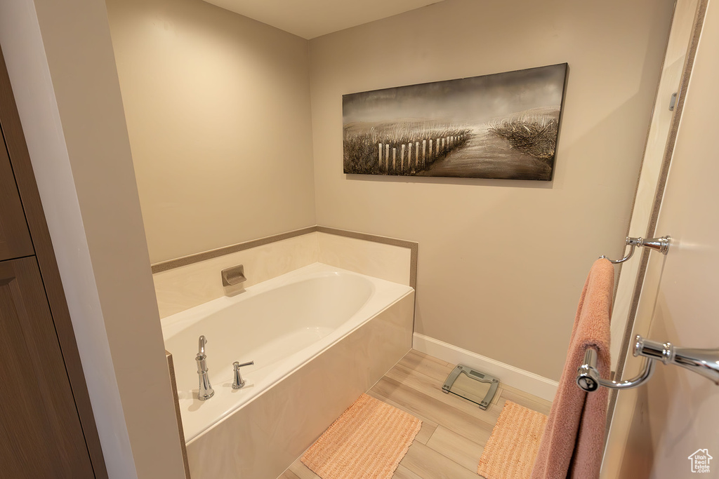 Bathroom featuring a garden tub and baseboards