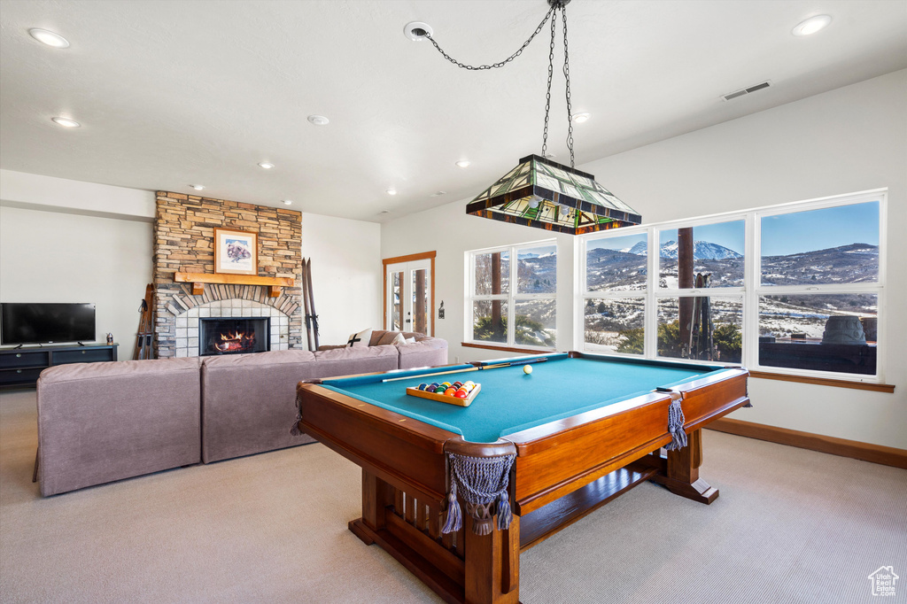 Recreation room with recessed lighting, visible vents, carpet flooring, a mountain view, and a stone fireplace