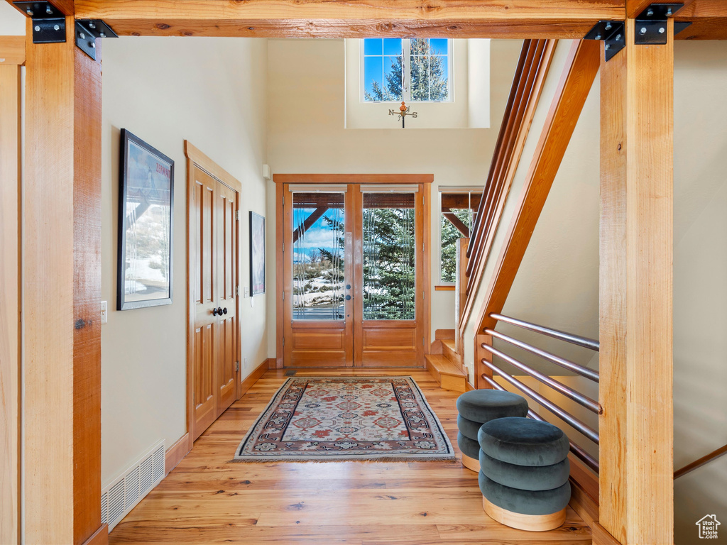 Foyer entrance featuring stairs, wood finished floors, visible vents, and baseboards