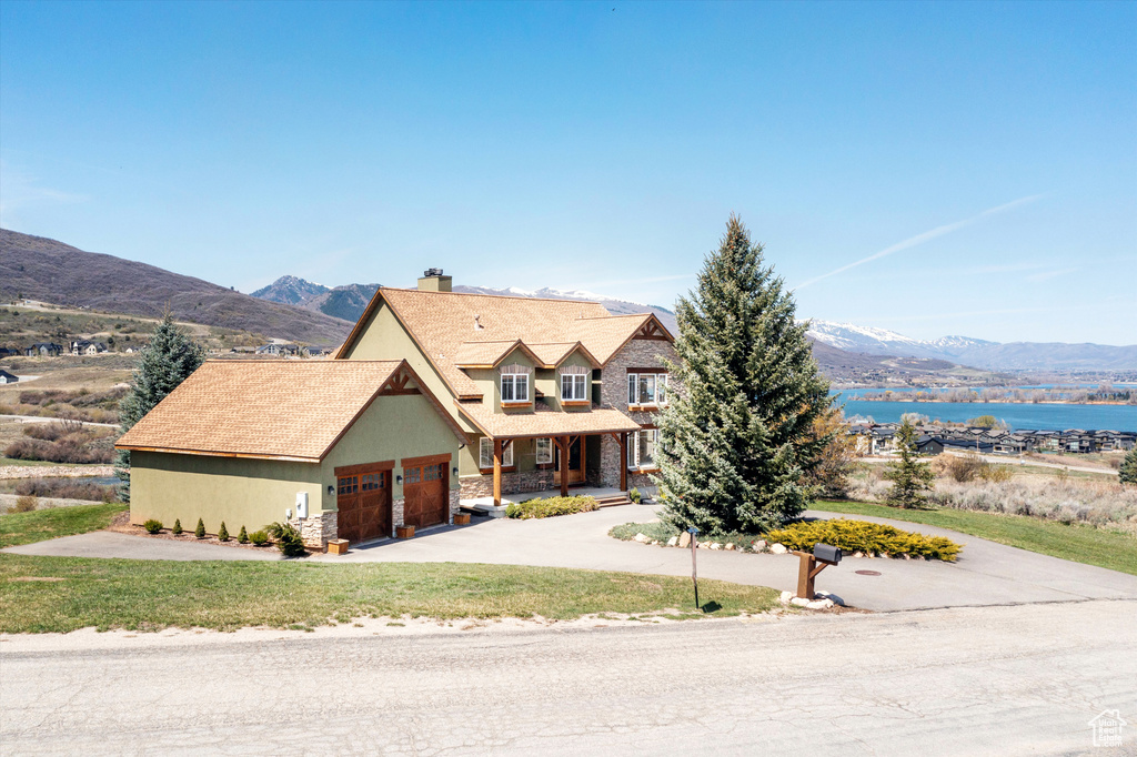 View of front of home featuring a chimney, a garage, driveway, and a front yard