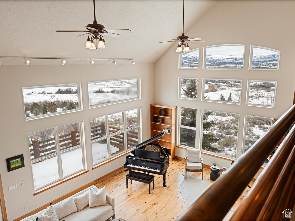 Interior space with light wood-type flooring, rail lighting, plenty of natural light, and high vaulted ceiling