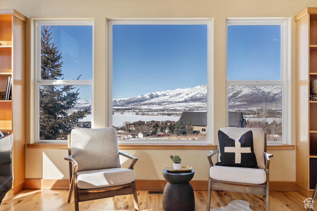 Sitting room featuring visible vents, a wealth of natural light, wood finished floors, and a mountain view