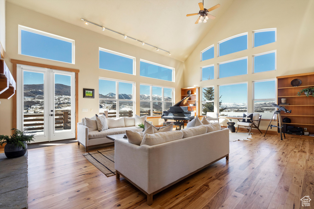 Living area featuring wood-type flooring, high vaulted ceiling, and track lighting