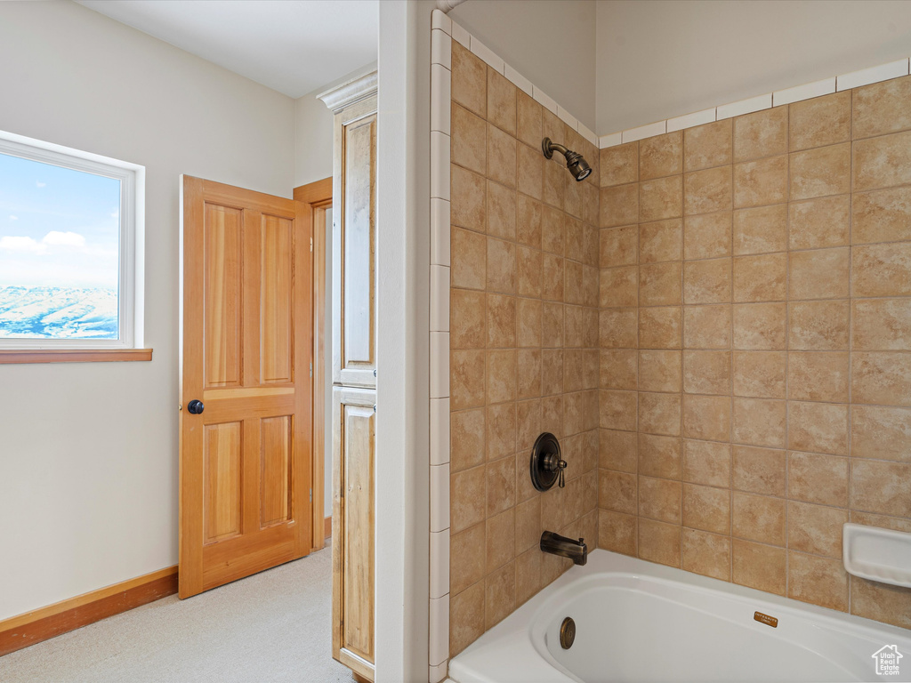 Bathroom featuring tub / shower combination and baseboards