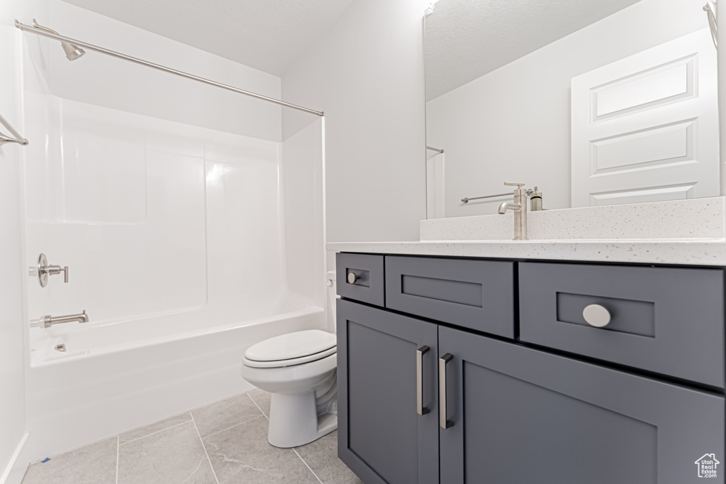 Full bathroom with toilet, vanity, shower / tub combination, and tile patterned floors