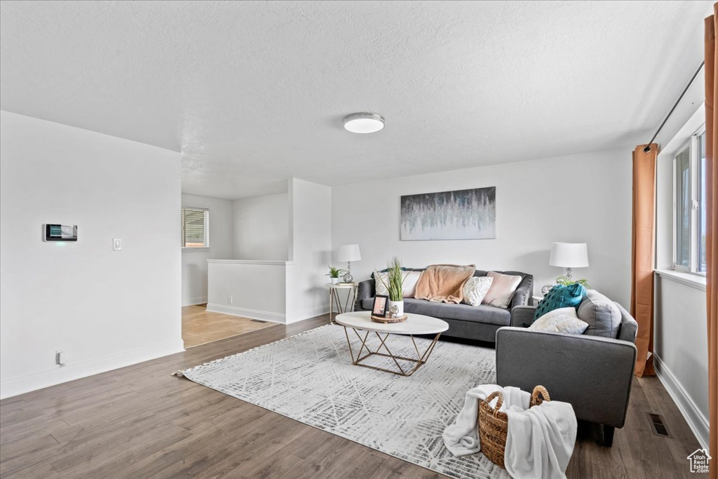 Living area with baseboards, visible vents, and wood finished floors