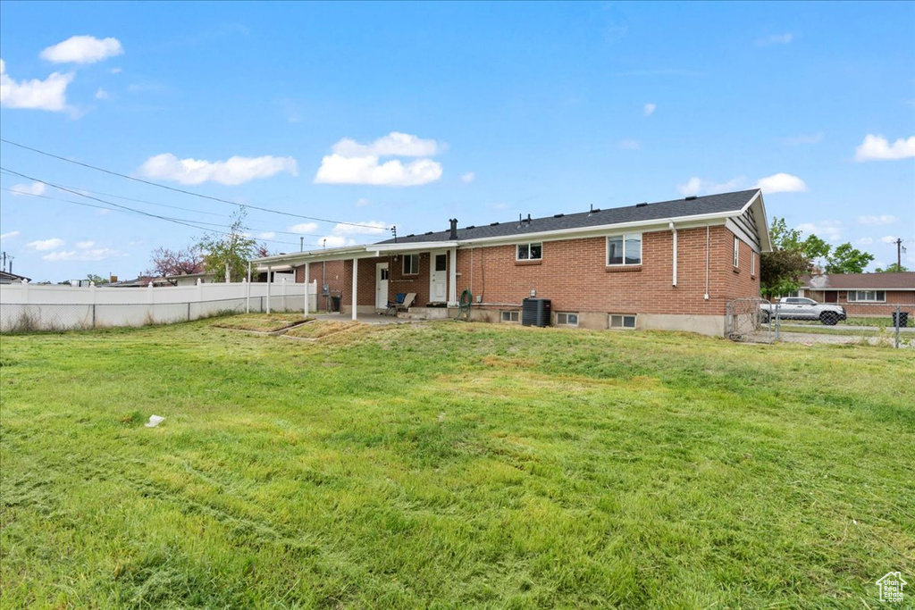 Back of property with central AC unit, a patio area, and brick siding