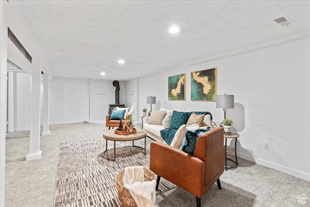 Living area featuring a wood stove, carpet, baseboards, and recessed lighting