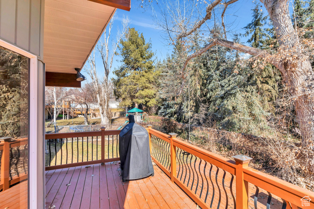 Deck with a lawn, a fenced backyard, and a grill