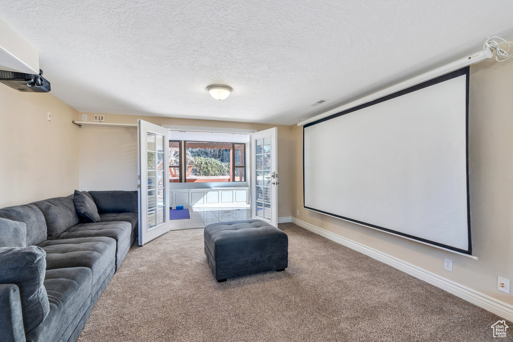 Cinema room featuring visible vents, baseboards, french doors, a textured ceiling, and carpet flooring