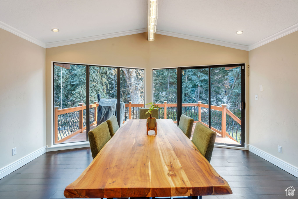 Unfurnished dining area with dark wood-type flooring, ornamental molding, lofted ceiling with beams, and baseboards