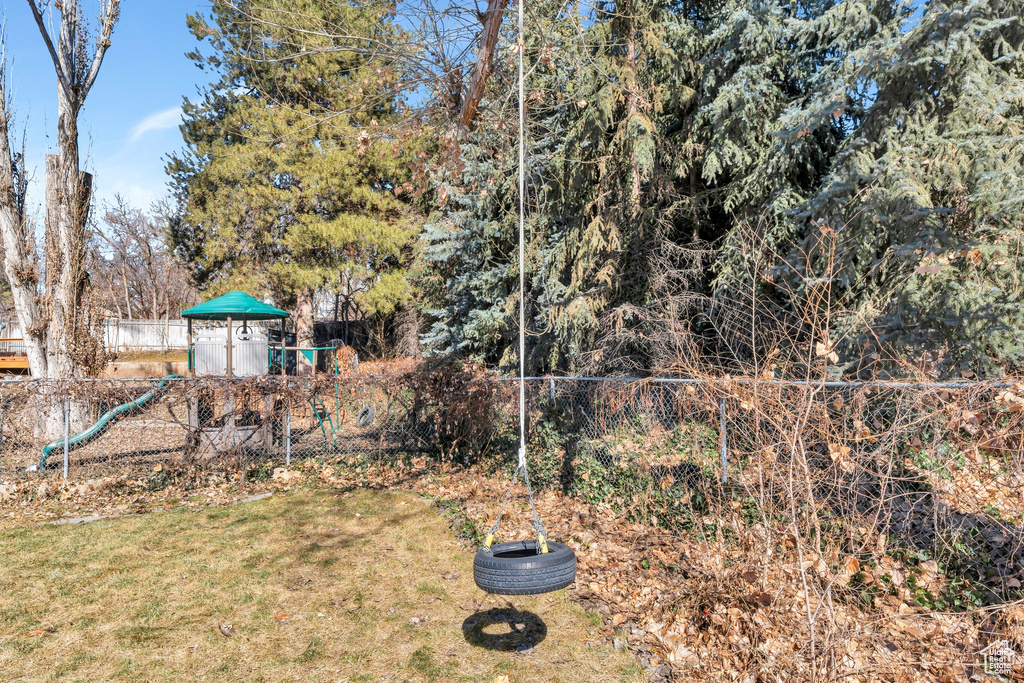 View of yard with a playground and fence