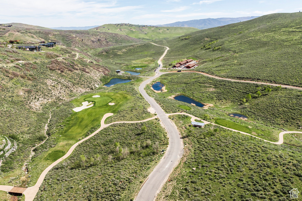 Aerial view of property and surrounding area with a water and mountain view and a local golf course