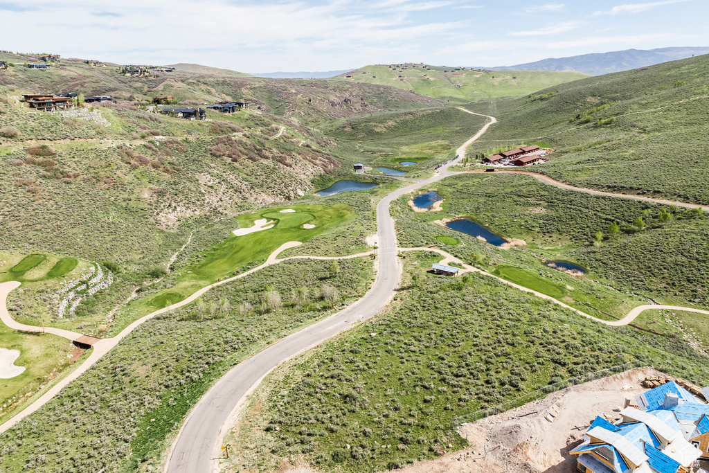 Drone / aerial view of a water and mountain view and a local golf course