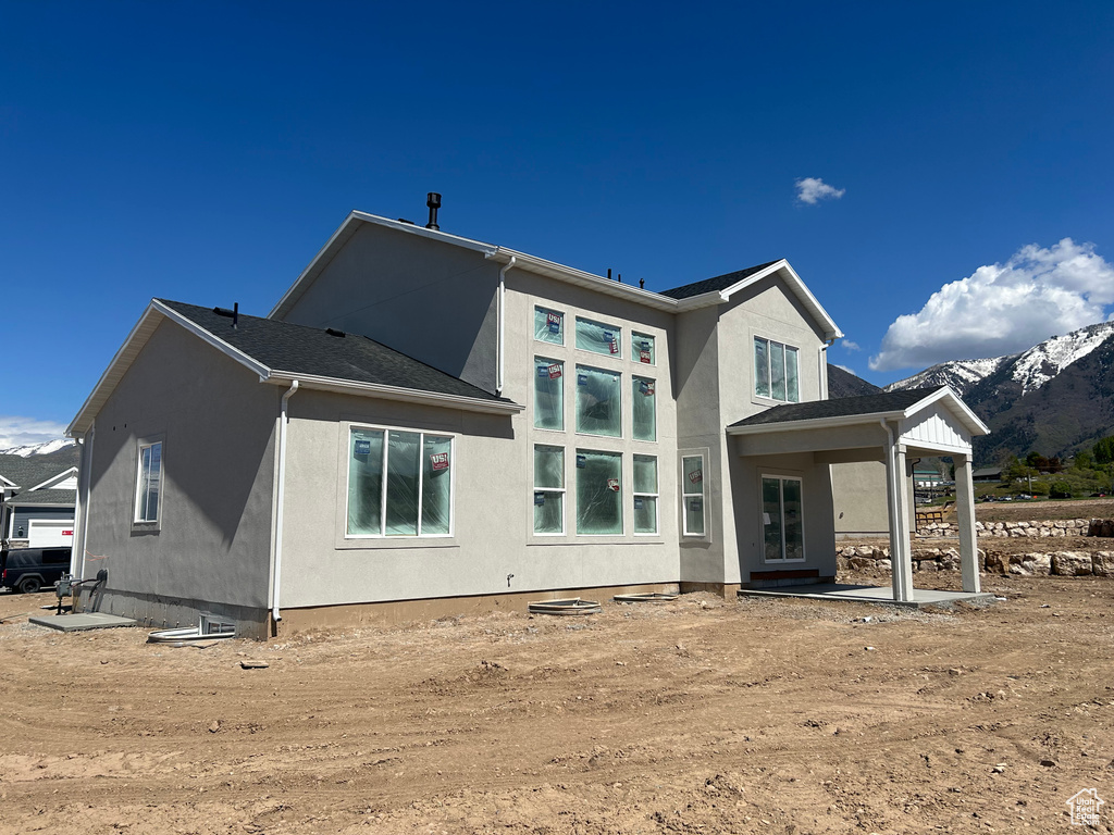 Back of house with stucco siding and a mountain view