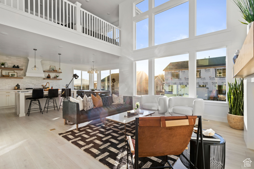 Living area with light wood-style flooring and a chandelier