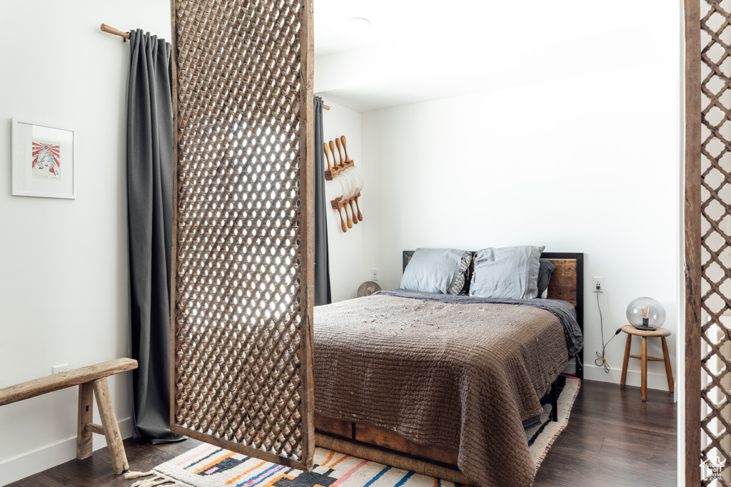 Bedroom with dark wood finished floors and baseboards