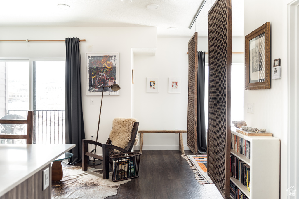 Living area featuring baseboards and dark wood-style flooring