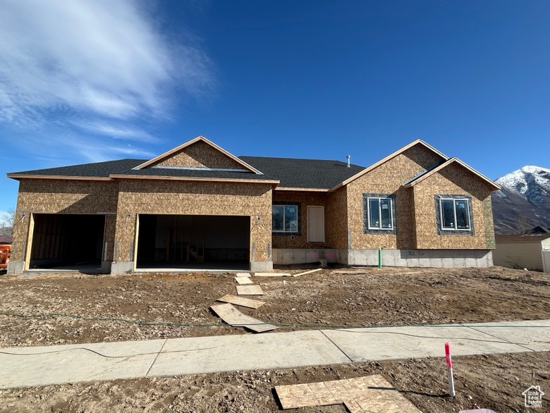 Property in mid-construction featuring an attached garage and a mountain view