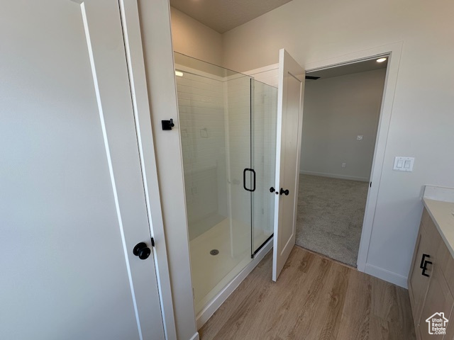 Full bath with a shower stall, wood finished floors, and vanity