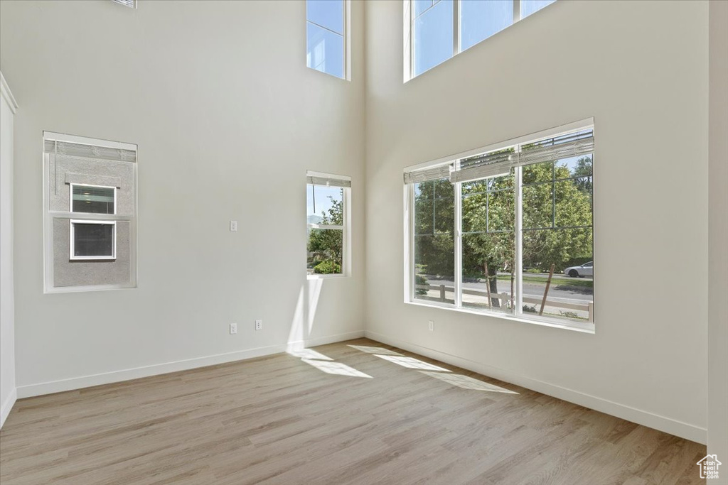 Spare room with wood finished floors and a towering ceiling