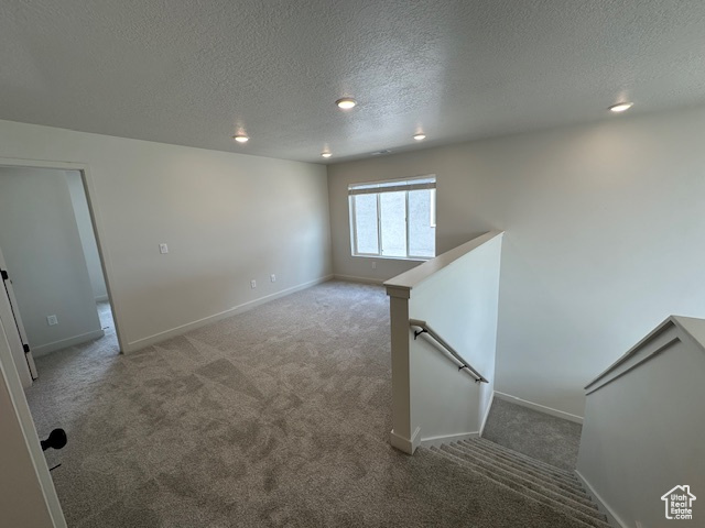 Unfurnished room with a textured ceiling, carpet, and recessed lighting